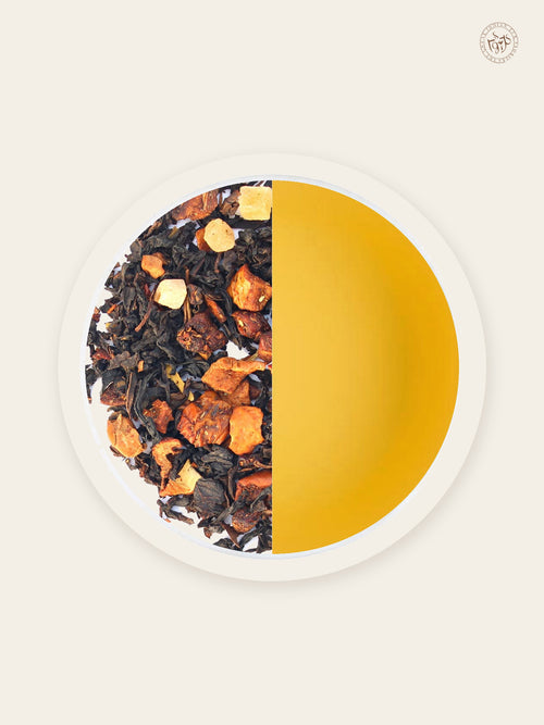 Peach black tea with freeze-dried peach beside sunlit amber tea liquor
