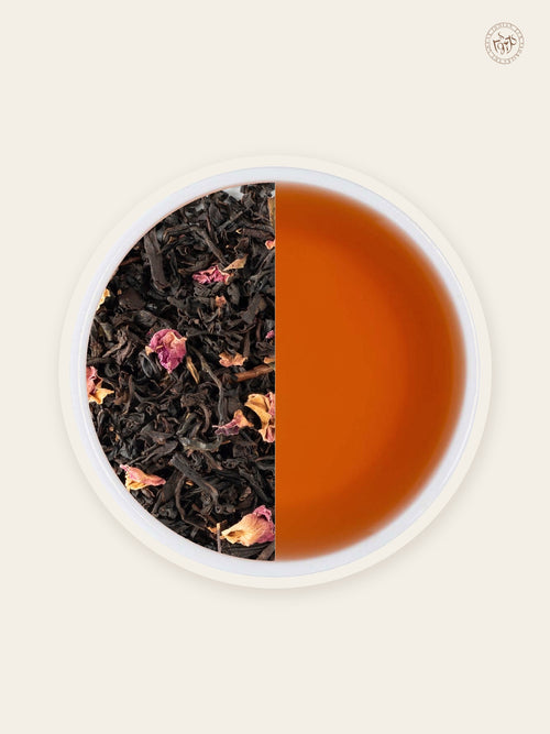 Rose black tea with rose petals beside warm blush-coloured tea liquor